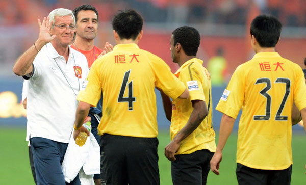 Marcello Lippi, head coach of Guangzhou Evergrande celebrates with players after the team's Chinese super league match against Shandong Luneng in Jinan, Shandong province, Oct 6, 2013. Lippi upbeat ahead of AFC Champions League title decider