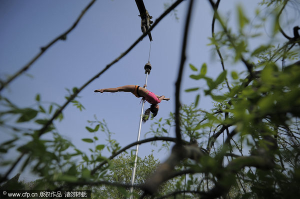 Crane hoists pole dancers in air