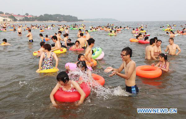 People swarm to beach to spend hot summer