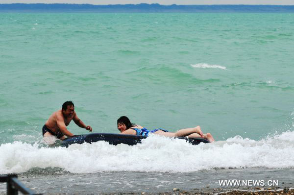 Tourists enjoy cool summer in Xinjiang's Ulunggur Lake
