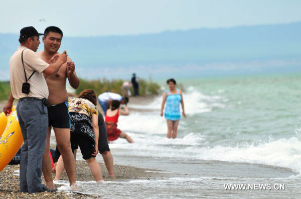 Tourists enjoy cool summer in Xinjiang's Ulunggur Lake