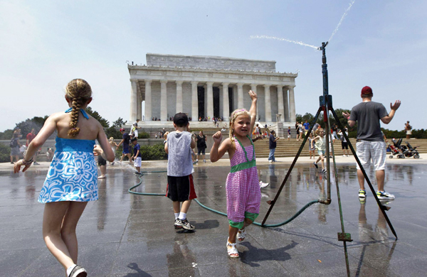 Children play with sprays of water in Washington