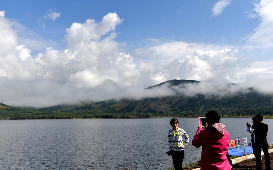 Mist-shrouded mountains seen near lakes in Arxan, N China
