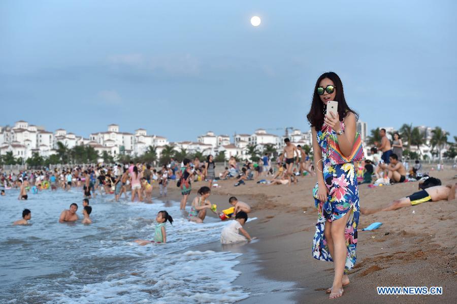 Haikou citizens play along beach in heat wave