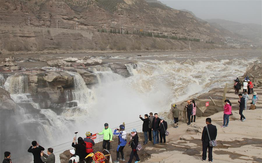 Surging water at Hukou Waterfall attracts tourists
