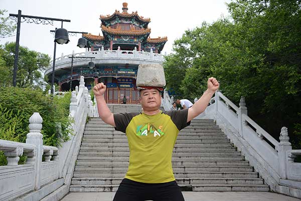 Man exercises with 40kg stone on his head