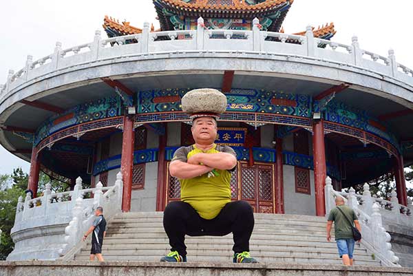 Man exercises with 40kg stone on his head