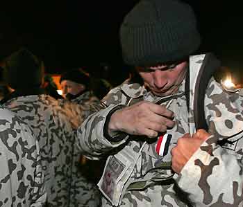 A Ukrainian serviceman pins an Iraqi medal to his uniform on his return from Iraq to Lviv airport, December 29, 2005. Ukraine on Thursday completed the withdrawal of its troops stationed in the city of Kut, southeast of Baghdad. 