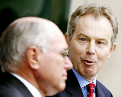 Britain's Prime Minister Tony Blair (R) reacts as his Australian counterpart John Howard answers questions during a news conference at the Parliament House in Canberra, Australia, March 28, 2006.