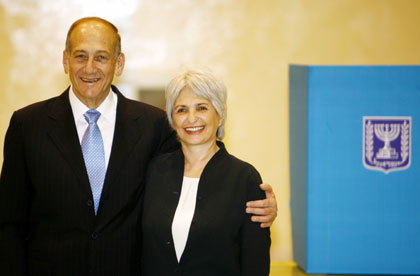 Israeli interim Prime Minister Ehud Olmert (L) embraces his wife Aliza after voting in Jerusalem on March 28, 2006. Israelis began voting in an election on Tuesday that interim Prime Minister Ehud Olmert has called a referendum on his plan to uproot remote settlements in the West Bank if peacemaking with the Palestinians stays frozen. 