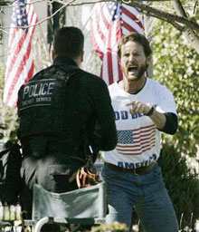 An unidentified intruder, right, shouts as he is approached by a member of the Secret Service Emergency Response Team on the North Lawn of the White House, Sunday, April 9, 2006 in Washington. The man was later taken into custody by the Secret Service. President Bush was in the White House at the time. (AP