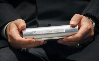Iran's Astan Qods Razavi museum chief carries a sample of enriched uranium after Iranian President Mahmoud Ahmadinejad speeches in Mashad, 924 km (574 miles) east of Tehran, April 11, 2006. Ahmadinejad said on Tuesday Iran had joined the group of countries possessing nuclear technology and was determined to achieve industrial-scale uranium enrichment.