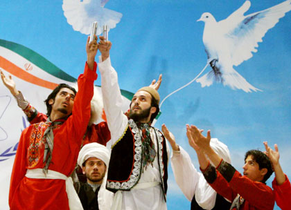 Iranian artists perform as they hold up samples of enriched uranium after Iranian President Mahmoud Ahmadinejad's speeches in Mashad, 924 km (574 miles) east of Tehran April 11, 2006. Ahmadinejad said on Tuesday Iran had joined the group of countries possessing nuclear technology and was determined to achieve industrial-scale uranium enrichment.