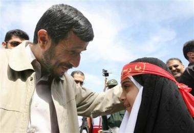 Iranian President Mahmoud Ahmadinejad greets a schoolgirl in Ferdos in Khorasan Razavi province, 890 km (530 miles) north east of Tehran, Iran, Thursday, April 13, 2006. [AP]