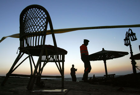 Egyptian policemen investigate the area in the Red Sea resort of Dahab April 25, 2006. Bombers have struck again at a resort in Egypt's Sinai Peninsula, killing at least 23 people in three nearly simultaneous explosions in a market and restaurant area popular with foreign tourists. 