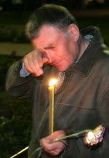 A man cries in front of a memorial dedicated to firefighters who died after the Chernobyl nuclear disaster, during a night service near the Chernobyl plant in the city of Slavutych, Ukraine April 26, 2006. [Reuters]
