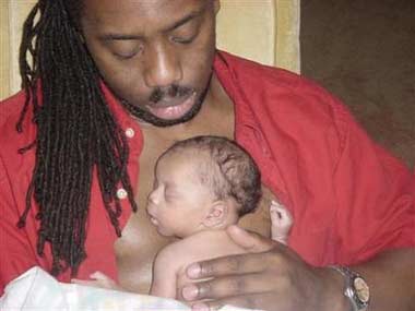 A father holds his baby in an undated file photo. Women can pick up cues about how men feel about children from their faces and use the subtle signs to rate them as potential partners, scientists said on Wednesday.
