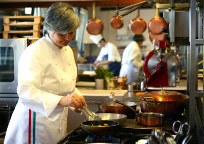 Chef Nadia Santini browns meat in a skillet at her Dal Pescatore restaurant in the northern Italian town of Canneto Sull'Oglio May 4, 2006. Santini is one of three female chefs of a total of five cooks in Italy who have won the coveted Michelin three-star award. Italy has 226 Michelin-starred chefs and 60 are women -- the highest number in any European country. [Reuters]