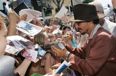 Actor Johnny Depp signs autographs for fans as he arrives for the world premiere of Warner Bros. Pictures' 'Charlie and the Chocolate Factory,' on Sunday, July 10, 2005, in Los Angeles. [AP Photo] 