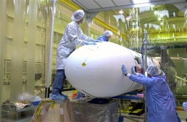 In this photo released by NASA, Orbital Sciences Corp. technicians at Vandenberg Air Force Base, Calif., finish installation of the fairing around the Demonstration of Autonomous Rendezvous Technology (DART) spacecraft on Oct. 15, 2004. The NASA spacecraft designed to autonomously carry out a series of tasks crashed into its target after using too much fuel halfway through its mission, according to a report summary released Monday, May 15, 2006. Investigators blamed the collision on faulty navigational data that caused the DART spacecraft to believe that it was backing away from its target when it was actually bearing down on it. (AP Photo