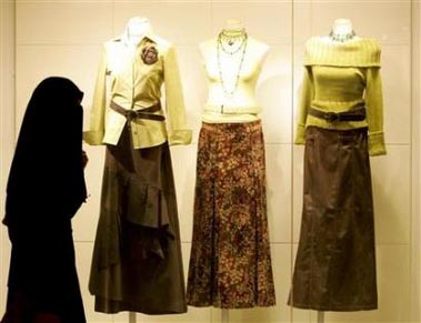 Saudi woman walks past a boutique at a shopping mall in Riyadh September 27, 2004. Saudi Arabia has postponed plans to replace male sales assistants in lingerie shops, saying it wants to give outlets more time to prepare for the move which has irritated the influential religious circles. [Reuters]