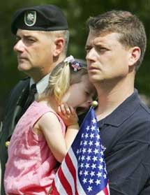 Iraq war veterans Air National Guard Master Sgt. Michael Gormley, right, of the West Roxbury neighborhood of Boston, holds his daughter Kate, 3, while standing next to and his brother, U.S. Army Lt. Col. Bill Gormley, during a Memorial Day service in the Gardens at Gethsemane cemetery in Boston, Monday, May 29, 2006. (AP Photo/