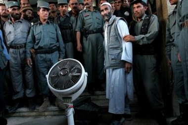 Afgan policemen present the media one of the looters, along with a stolen fan and television a day after protests in Kabul, Afghanistan, Tuesday, May 30, 2006. Rioters on Monday stoned the U.S. convoy involved in the accident, then headed to the center of Kabul, ransacking offices of international aid groups and searching for foreigners while chanting 'Death to America!'. [AP]