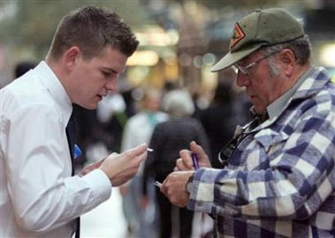 A plain clothed Sydney City Council ranger (R) fines a smoker for dropping a butt on a city street, May 31, 2006.