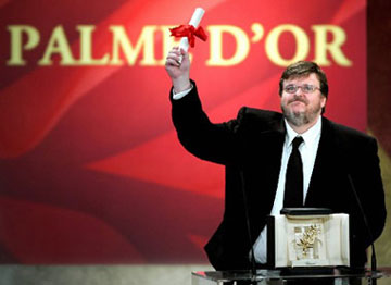 U.S. director Michael Moore reacts as he holds the Palme d'Or for his winning film entry "Fahrenheit 9/11" during the awards ceremony at the 57th Cannes Film Festival , May 22, 2004. The film, by Michael Moore, is a documentary that criticizes US President and the war in Iraq. [Reuters]