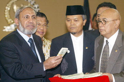 Palestinian Foreign Minister Mahmoud al-Zahar (L) receives US$90,000 donated by Indonesian Muslim groups in Indonesia May 26, 2006. Al-Zahar called on Indonesia on Friday to take a role in the troubled Middle East peace process, and won a promise of support from the world's most-populous Muslim country.