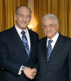 In this picture released by the Israeli Government Press Office, Israeli Prime Minister Ehud Olmert, left, shakes hands with Palestinian President Mahmoud Abbas, also known as Abu Mazen, after a breakfast hosted by Jordan's King Abdullah, not seen, during a conference of Nobel Prize laureates in the ancient city of Petra, Jordan, Thursday June 22, 2006. Their meeting is the first between the two since Olmert took office in January, but officials said there would be no formal talks between them at the Jordan conference. [AP]