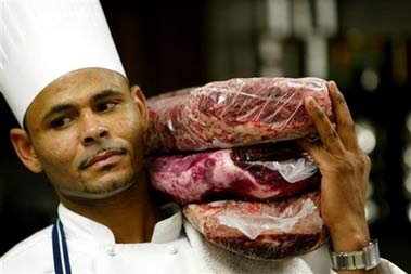 Chioke Carter carries the three types of meats used in the 20-ounce, $100 slab of ground beef, billed as the 'beluga caviar of hamburgers' Tuesday, June 20, 2006 at the Old Homestead Steak House in Boca Raton, Fla. The burger combines the most expensive cuts of beef from the U.S., Japan and Argentina. (AP Photo