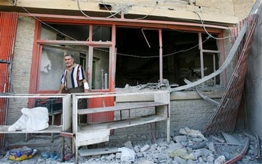 Baker Mahdi Qassim, who rented his premises from the owner, inspects what remains of his business after gunmen shot dead Mahdi Murad, the owner of a bakery and supermarket, then left after leaving a timed bomb inside the bakery, in the New Baghdad area of Baghdad, Iraq Monday, June 26, 2006. There were no further casualties. (AP Photo/Khalid Mohammed)