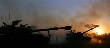 An Israeli soldier reloads a mobile artillery piece after firing towards the Gaza Strip at a position near Kibbutz Nahal Oz, just outside the northern Gaza Strip,Thursday June 29, 2006. [AP]