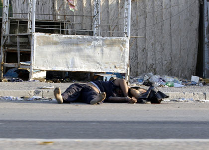 Two men lie on the road shortly after they were shot by gunmen in Baghdad July 9, 2006. Gunmen shot dead eight people at fake checkpoints in Baghdad's Sunni Jihad district on Sunday, close to a Shi'ite mosque where a car bomb killed three people on Saturday night, police said.