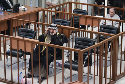 Abdullah Kadhem Ruaid (L), a former official in former Iraq's leader Saddam Hussein's ruling Baath party in Dujail, adjusts his headscarf as co-defendant, Ali Daei, a minor Baath party official from Dujail, watches during final arguments for their trial in Baghdad's heavily fortified Green Zone July 11, 2006. Saddam Hussein and his lawyers again boycotted his trial on charges of crimes against humanity on Tuesday.