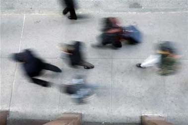 Morning commuters on the city sidewalks of New York, December 20, 2005. Working long hours has a greater negative impact on women than men because it makes them more likely to smoke, drink coffee and eat unhealthy food.