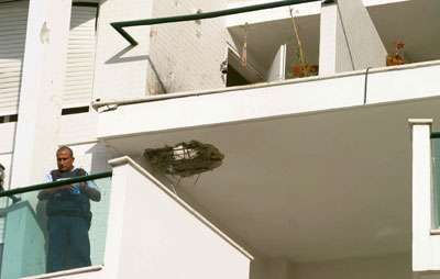 An Israeli policeman stands in a building which was hit by a rocket in the northern town of Nahariya near the Israeli-Lebanese border July 13, 2006. Israel struck Beirut airport and Hizbollah's television station on Thursday and killed 22 civilians in raids on south Lebanon, intensifying its reprisals after Hizbollah captured two Israeli soldiers and killed eight.