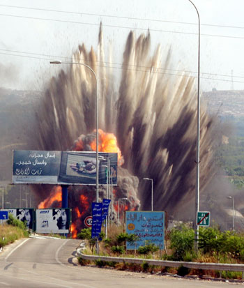 Debris flies after Israeli jets fired missiles at the Zahrani bridge in south Lebanon July 14, 2006.
