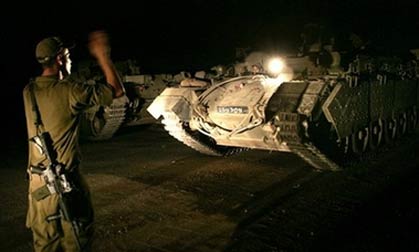 Israeli army armored vehicles maneuver at a staging area at the border crossing between Israel and Lebanon in Rosh Hanikra, northern Israel , Wednesday July 19, 2006. 