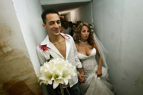 Israeli couple Shlomi Bouskila (L) and Maya Lougasi go down to a bomb shelter during their wedding ceremony in the town of Kiryat Shmona, in northern Israel July 20, 2006.