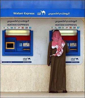 A resident of Kuwait City gets money from a National Bank of Kuwait (NBK) affiliated machine. The one million citizens of Kuwait, where government financial assets have topped 166 billion dollars, are to receive a grant of 200 dinars (690 dollars) each, the government has announced.(AFP