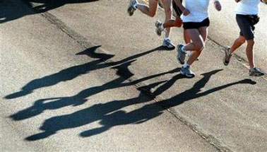 Runners cast shadows in the early morning as they run in this September 12, 2004 file photo. The longest foot race in the world is 3,100 miles, long enough to stretch from New York to Los Angeles.