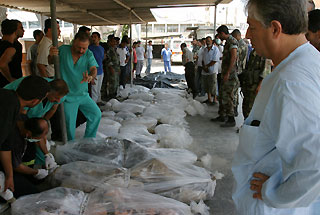 Medical personnel line up bodies outside Tyre hospital after an Israeli air raid on Qana killed at least 54 civilians, including 37 children, in south Lebanon, July 30, 2006.