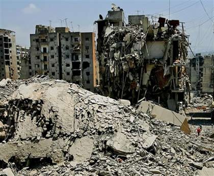 A high rise apartment building, left, reduced to rubble in the southern suburbs of Beirut, Lebanon, Monday, July 31, 2006. After over two weeks of sustained Israeli airstrikes on the previously densely-populated Hezbollah-controlled area of the capital few civilians remain, though some ventured back Monday to salvage belongings taking advantage of the 48 hour pause in airstrike. [AP Photo] 