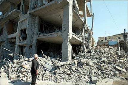 A looks at a destroyed building in the southern Lebanese town of Nabatiyeh. Shock and fury at an Israeli air strike that killed 52 Lebanese civilians, mostly sleeping children, rippled across the world from the United Nations to the streets of Arab capitals.[AFP]