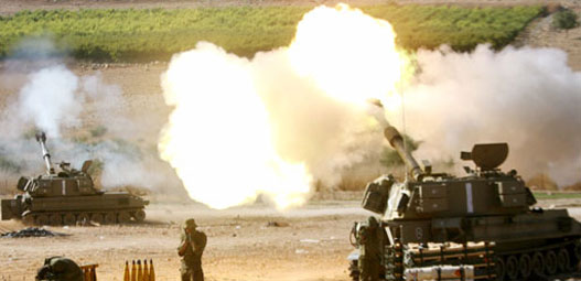 Israeli soldiers stand behind 155mm mobile artillery firing into southern Lebanon, from a position on the Israeli-Lebanese border August 6, 2006. Hizbollah killed 11 Israeli soldiers on Sunday in its deadliest rocket strike yet and Israeli bombs killed 18 Lebanese civilians as Lebanon rejected a draft U.N. resolution to end the 26-day-old war.