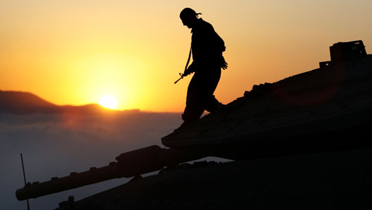 An Israeli soldier walks on a tank in northern Israel near the Israel-Lebanon border August 7, 2006.