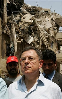 Lebanon's Prime Minister Fuad Saniora walks past a destroyed building in the southern suburbs of Beirut, Lebanon, Sunday, Aug. 20, 2006. Saniora, standing amid the rubble of devastated streets in Beirut's southern suburbs, accused Israel Sunday of committing a 'crime against humanity' by its destruction of Lebanon. (AP Photo