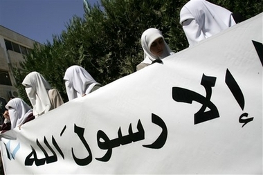 Muslim veiled women holds a poster during a protest against Pope Benedict XVI's recent remarks about Islam, in Amman, Jordan, Monday, Sept18, 2006. Dozens of Muslims and Christians deputies and professional association members protested against the Pope's quoting from an obscure Medieval text, cited the words of a Byzantine emperor who characterized some of the teachings of the Prophet Muhammad, Islam's founder, as 'evil and inhuman'.(AP